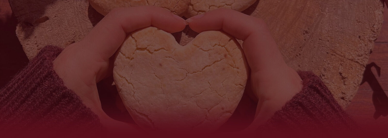 Manos sosteniendo una galleta con forma de corazón
